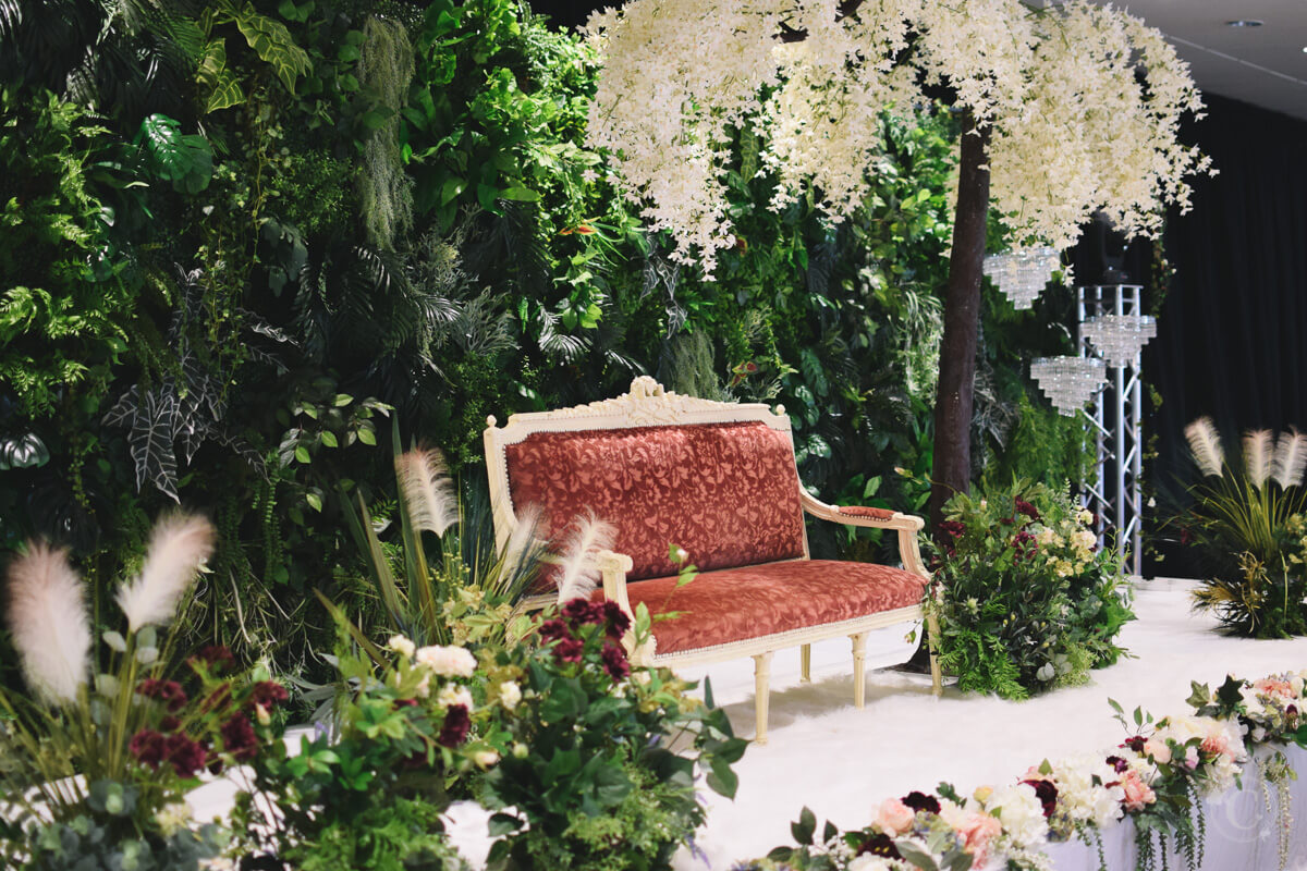 Lush forest wall backdrop, cinderella tree arch, vintage dusky pink lounger, garden bush, florals