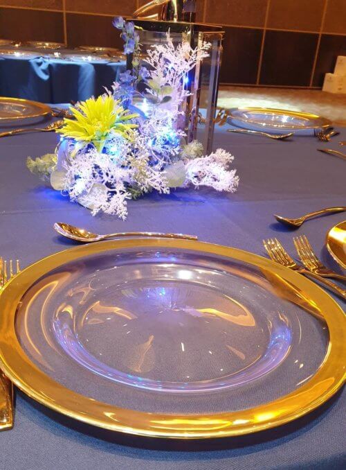 Table setting with gold rim glass charger plate