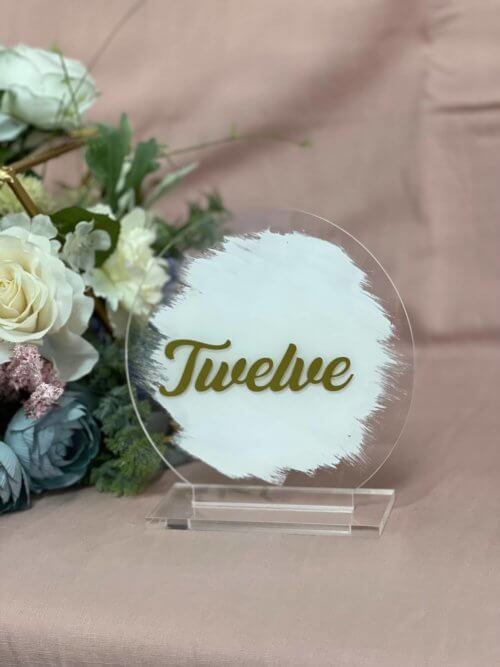 Round acrylic gold table number painted with white background